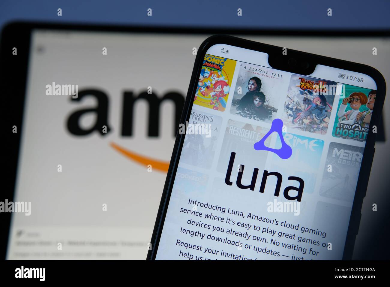 Amazon Luna Cloud-Gaming-Login-Seite auf dem Bildschirm des Smartphones und verschwommenes Amazon-Logo auf der Rückseite gesehen. Luna Plus ist ein Abonnement für neue Spiele Stockfoto