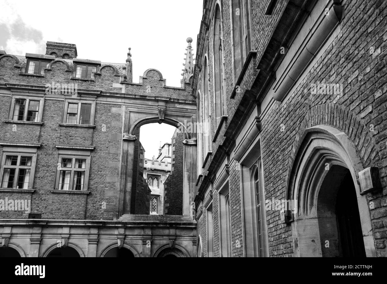 Cambridge (Vereinigtes Königreich). Architektonische Details. Blick von der Straße durch die Öffnung zum Innenhof. Schwarzweiß-Foto. Stockfoto