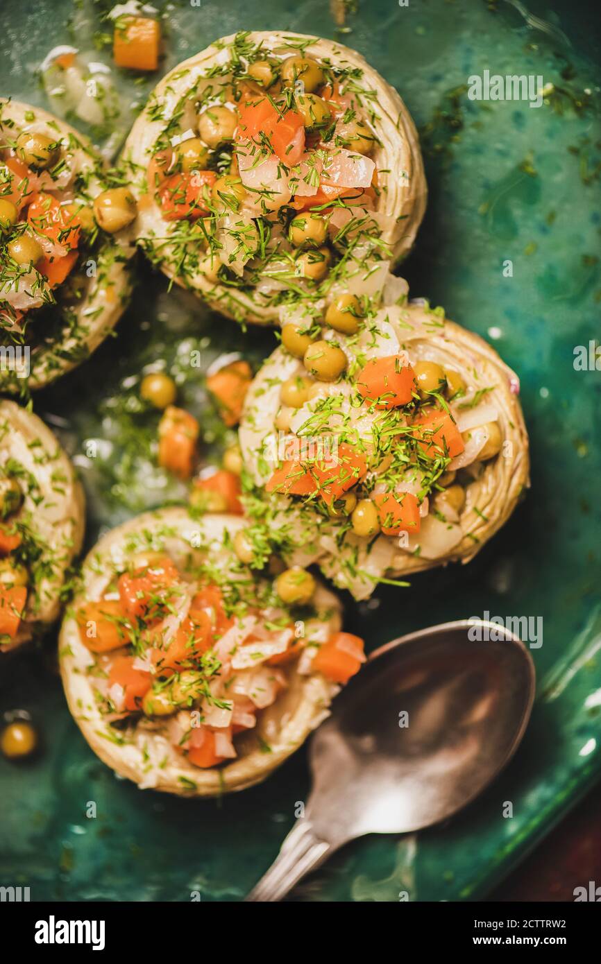 Türkischer traditioneller veganer Artischockensalat mit geschmortem Gemüse auf dem Teller Stockfoto