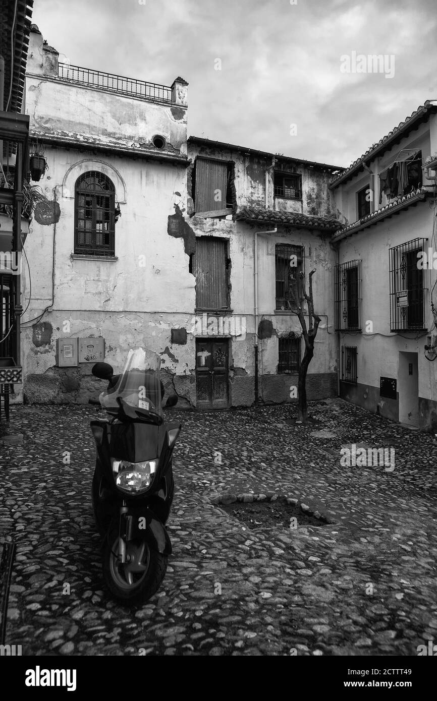 Placeta Capellanes, El Albaicín, Granada, Andalusien, Spanien: Motorroller und fotogener Verfall im alten maurischen Viertel. Schwarz-Weiß-Version Stockfoto