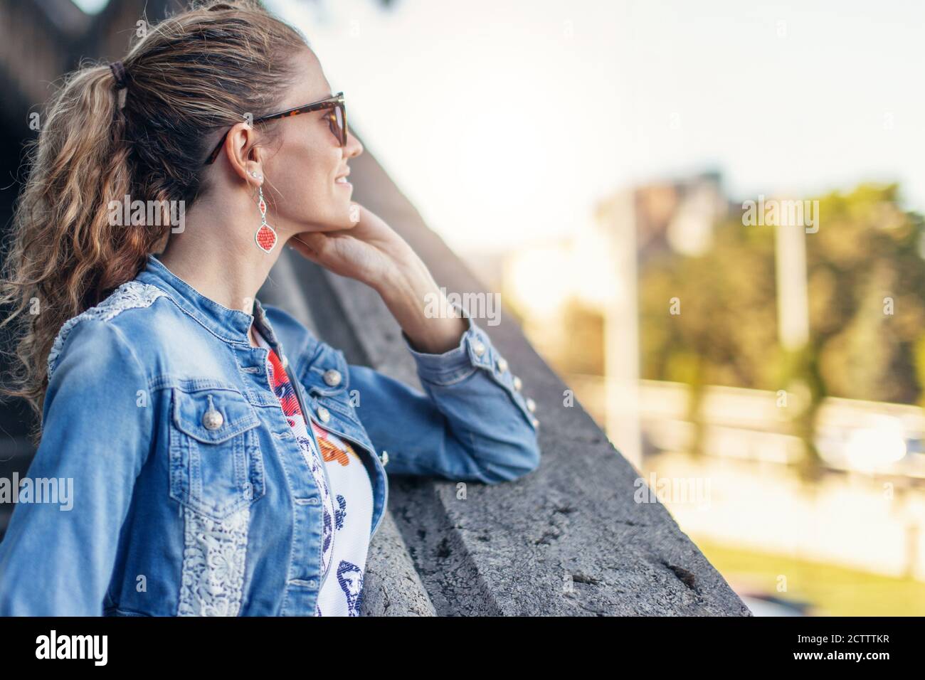 Junge Frau in Jeansjacke im Herbst Blick weg in parken Stockfoto