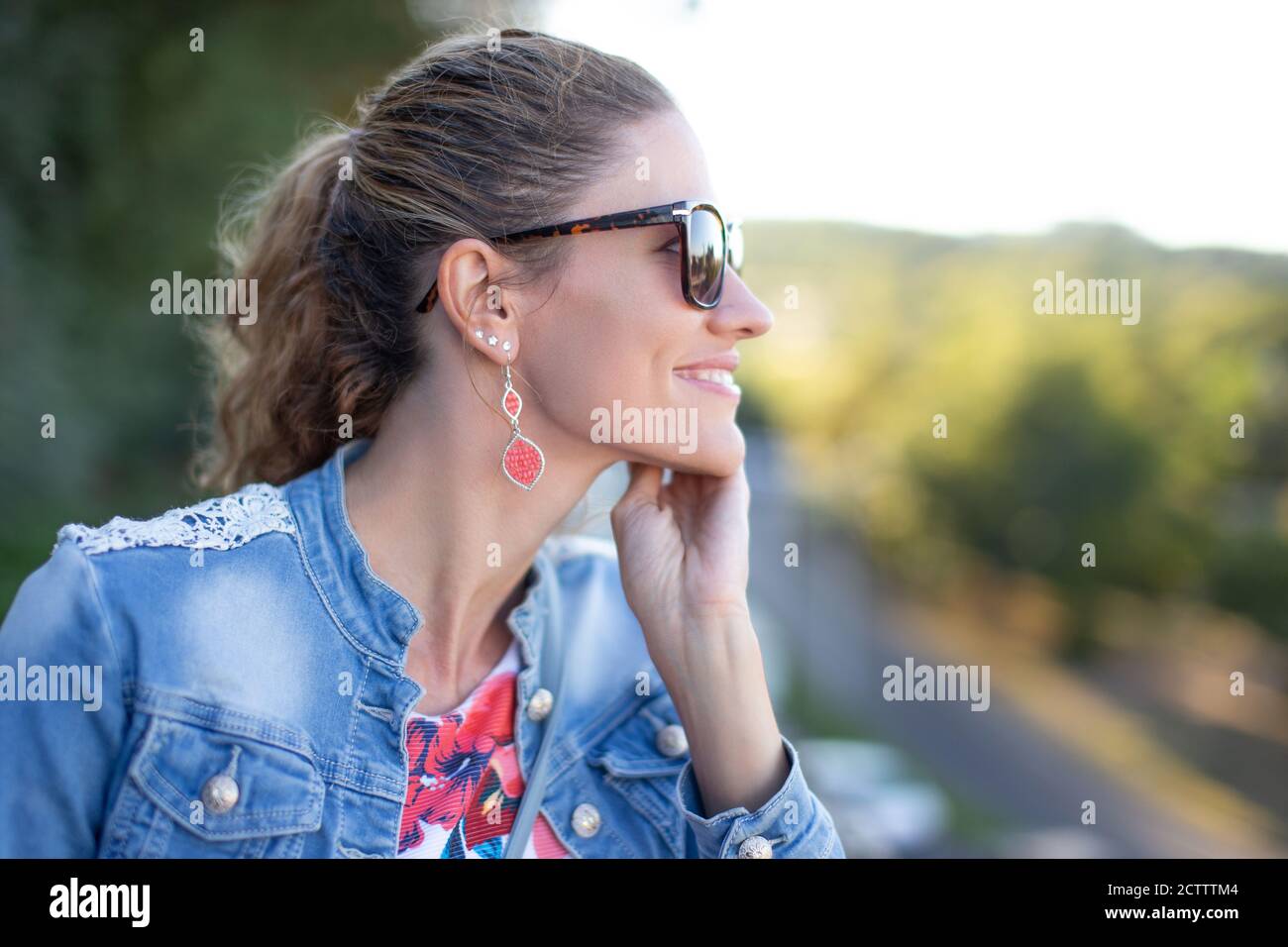 Junge fröhliche Frau Profilansicht Porträt im Park Stockfoto
