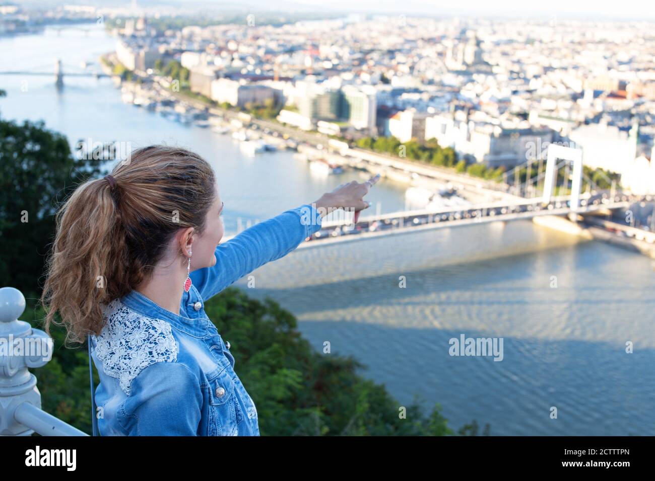 Junge Frau, die von oben auf die Ziele der Stadt zeigt, Sightseeing, Budapest, Ungarn Stockfoto