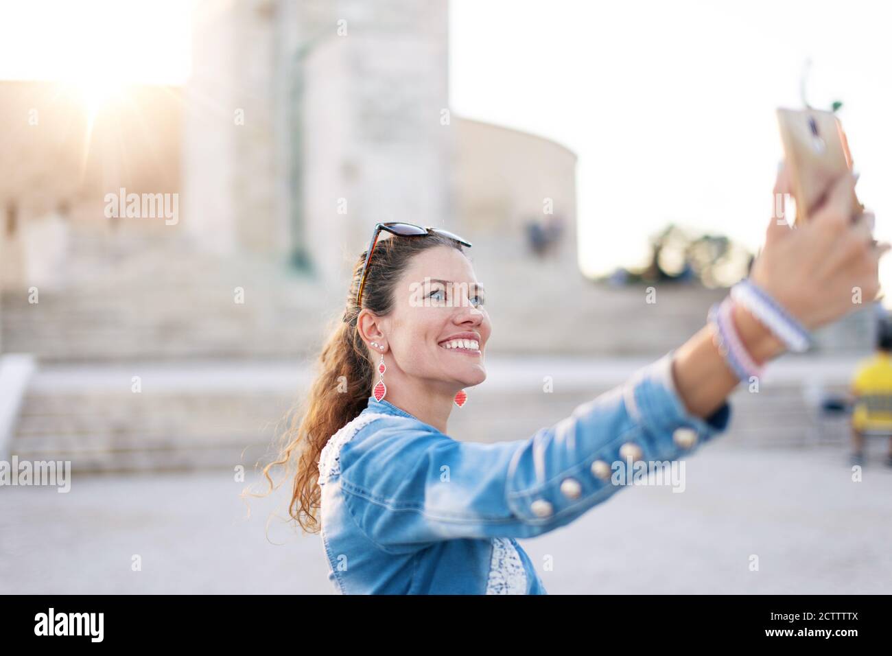 Junge urbane Frau, die Selfie an einem berühmten Ort in der Stadt nimmt Stockfoto