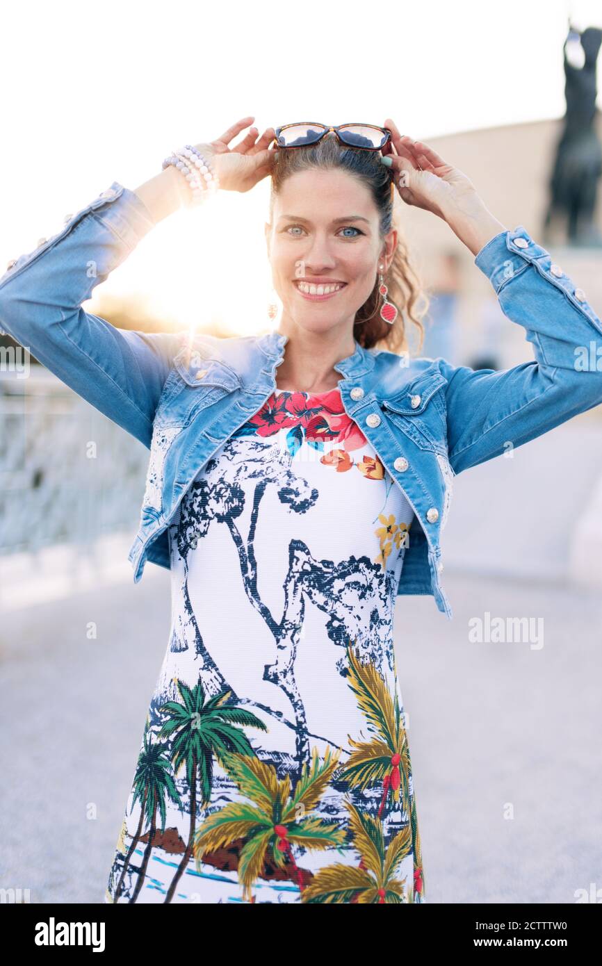 Stilvolle junge urbane Frau toothy Lächeln im Sonnenuntergang, im Freien in der Stadt Stockfoto