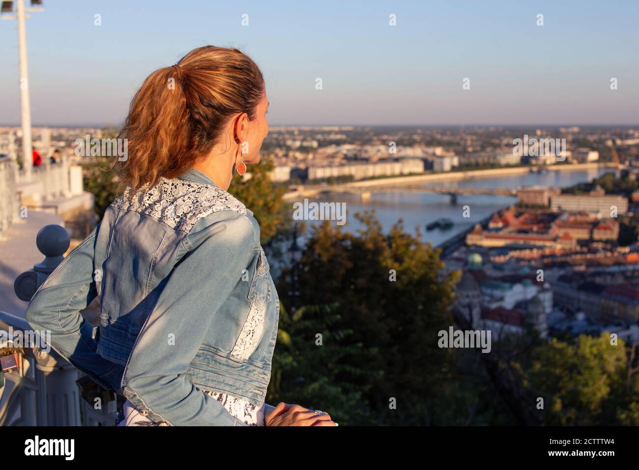 Junge Stadtfrau wundert sich in der Stadt Panorama Sonnenuntergang Stockfoto