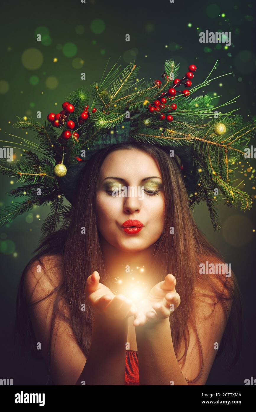 Schöne Frau weht Fee und magischen Staub. Feiertage und Weihnachten Stockfoto