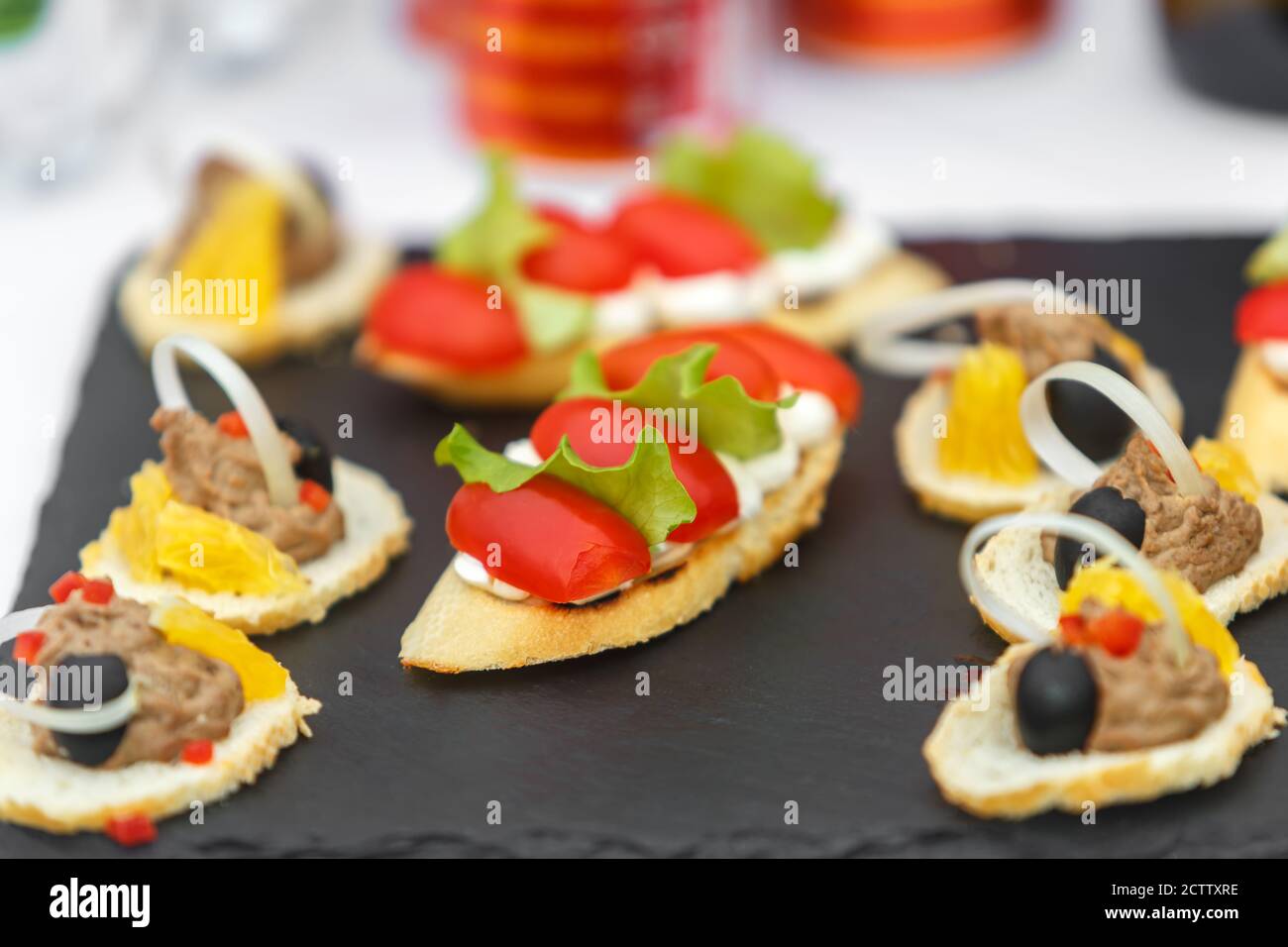 Sandwiches mit Tomaten, Salat und Oliven auf einem Schieferteller Stockfoto