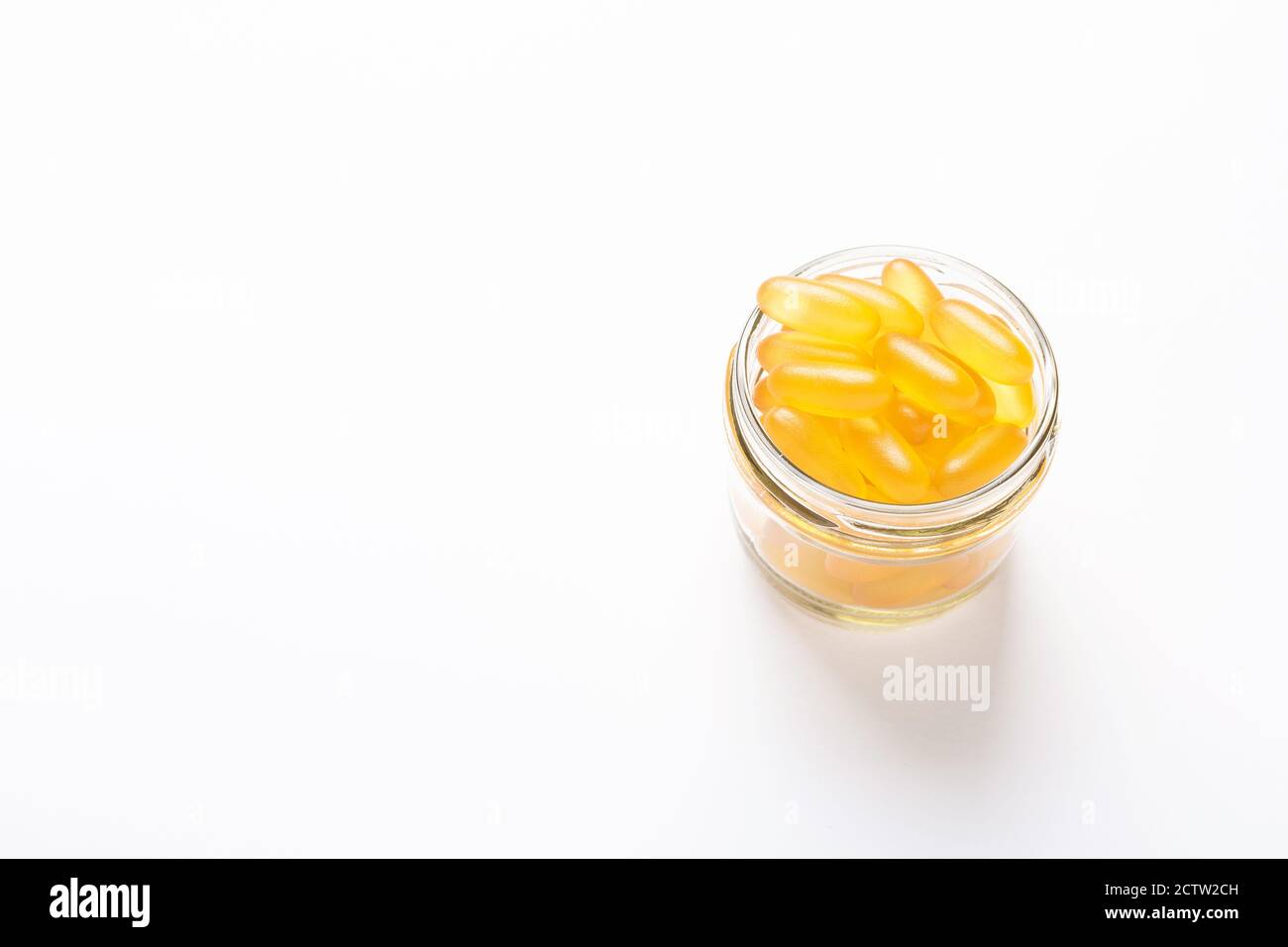 Omega 3 Kapseln im Glas auf weißem Hintergrund Fischöl Gelbe Softgels Vitamin D, E, EIN Ergänzungskonzept der Gesundheitsversorgung Copy Space Selektiver Fokus Stockfoto