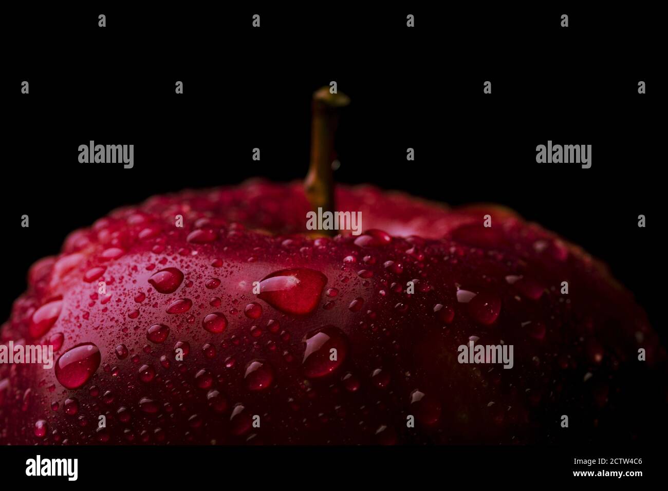 Frischer roter Apfel auf schwarzem Hintergrund. Äpfel mit Wassertröpfchen. Makroaufnahme Stockfoto