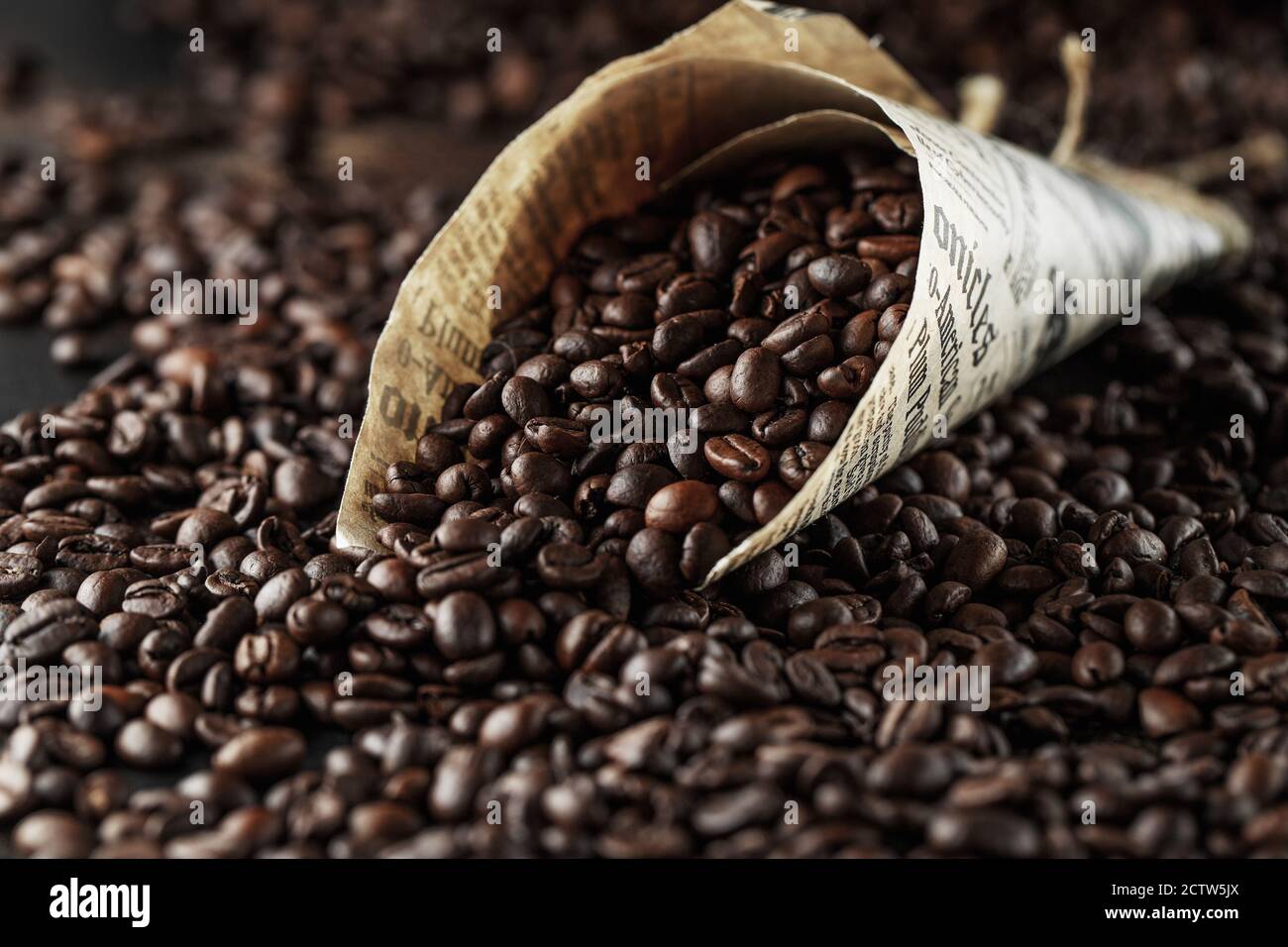 Schwarze Kaffeebohnen Studioaufnahme. Frisch geröstete Kaffeebohnen in einem Papierkegel Stockfoto