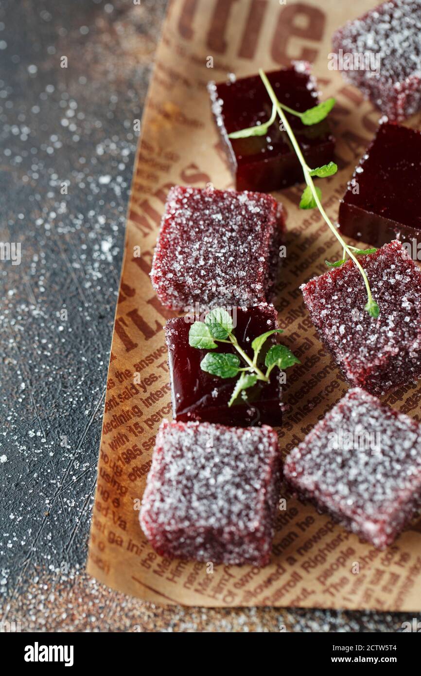Hausgemachte bunte Marmelade Süßigkeiten in Zucker auf dunklem Hintergrund. Fruchtgelee Süßigkeiten. Obst Kaubonbons. Jelly Bean. Sortiment von bunten Früchten j Stockfoto