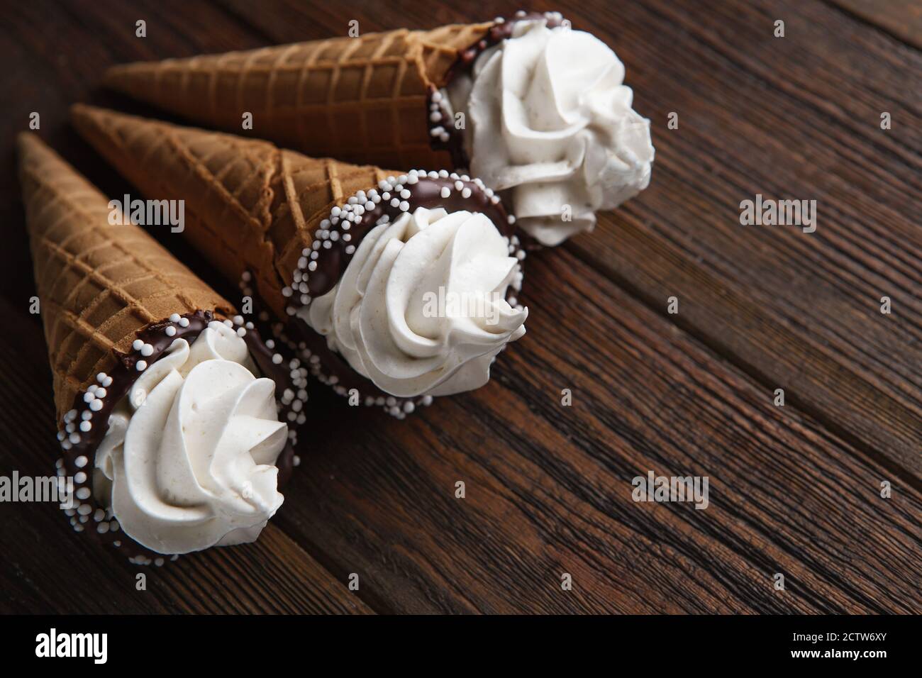 Eiszapfen auf Holztisch. Weiches Eis oder gefrorene Cremes in Zapfen. Eiscreme mit Waffel-Marshmallow Stockfoto