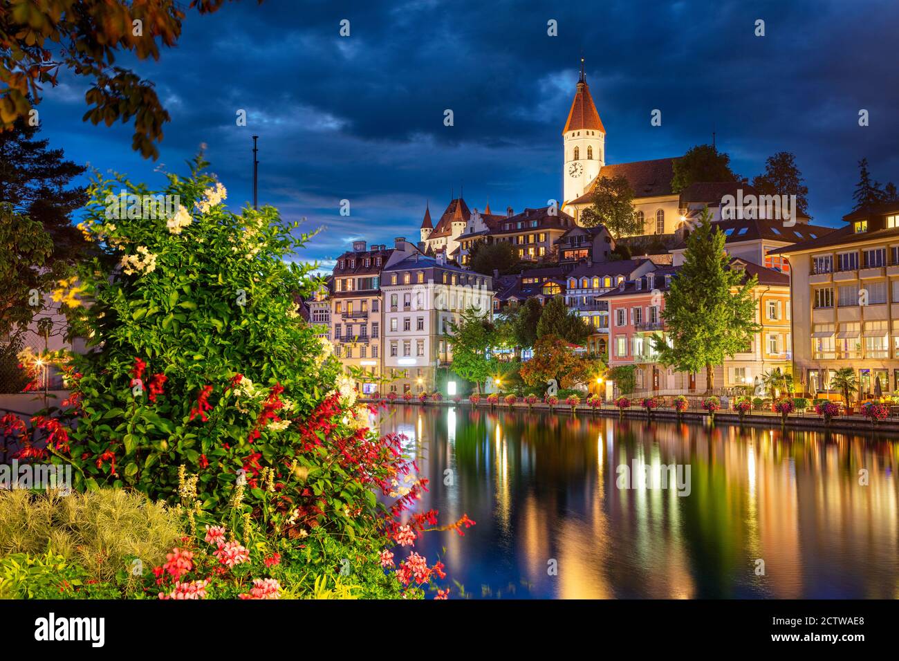 Thun, Schweiz. Stadtbild der schönen Stadt Thun mit der Reflexion der Stadt in der Aare Fluss in der Nacht. Stockfoto