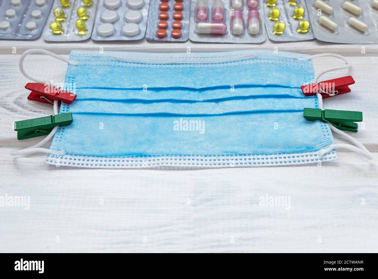 Medizinische Flatlay mit Maske und Tabletten auf weißem Holzhintergrund. Medizinisches Konzept. Draufsicht. Stockfoto