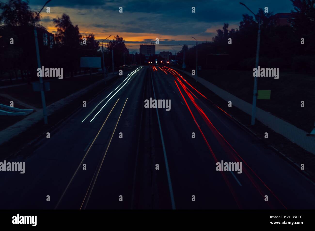 Lange Exposition des Verkehrs auf der Straße in der Stadt bei Sonnenuntergang. Stockfoto