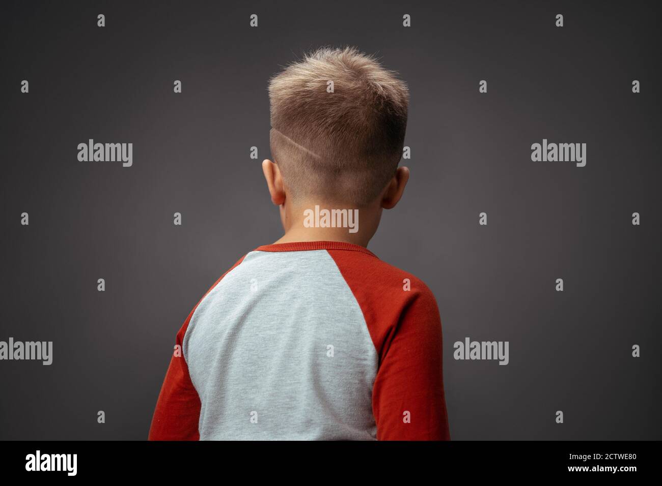 Kind drehte den Rücken zur Kamera. Kinderdrama Konzept. Junge beleidigt durch isolierten Hintergrund. Hochwertige Fotos Stockfoto