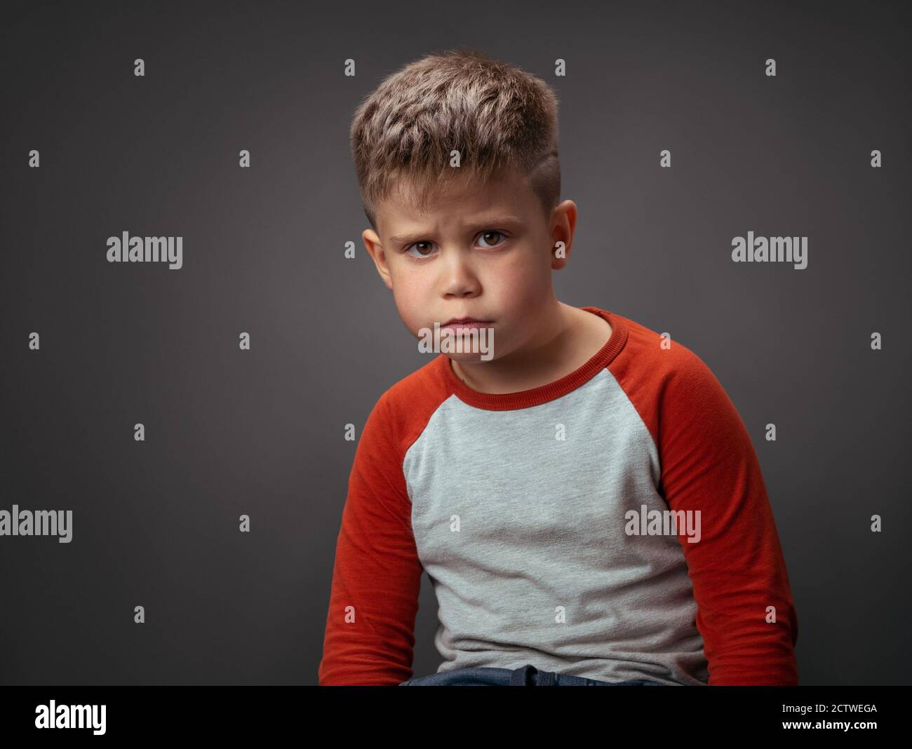 Beleidigte Junge schaut in die Kamera. Der Groll der Kinder ist ein Konzept. Trauriges Kind im Studio auf einem isolierten Hintergrund. Hochwertige Fotos Stockfoto