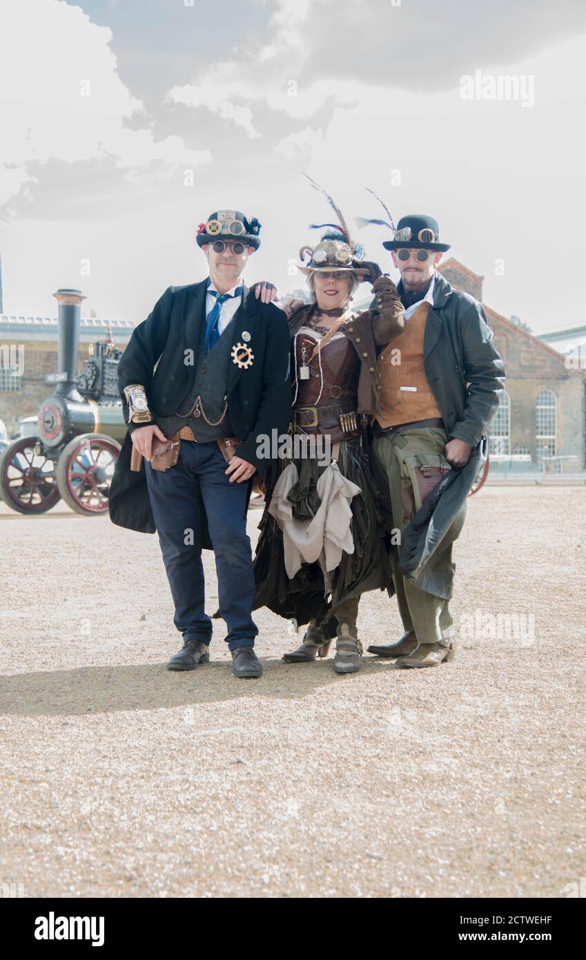 Dampf Punk Schauspieler in Vollkostüm mit Zugmaschine dahinter Sie bei Chatham Dockyard Stockfoto