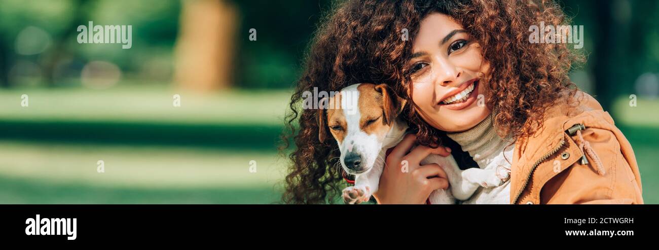 Panorama-Aufnahme der Frau umarmt Jack russell Terrier im Freien Stockfoto