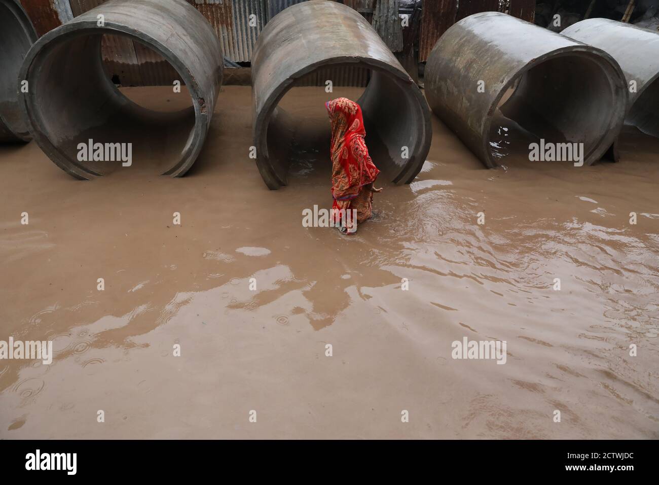 Eine bangladeschische Frau geht durch eine überflutete Straße in Dhaka, Bangladesch, 07. Juli 2018. Stockfoto