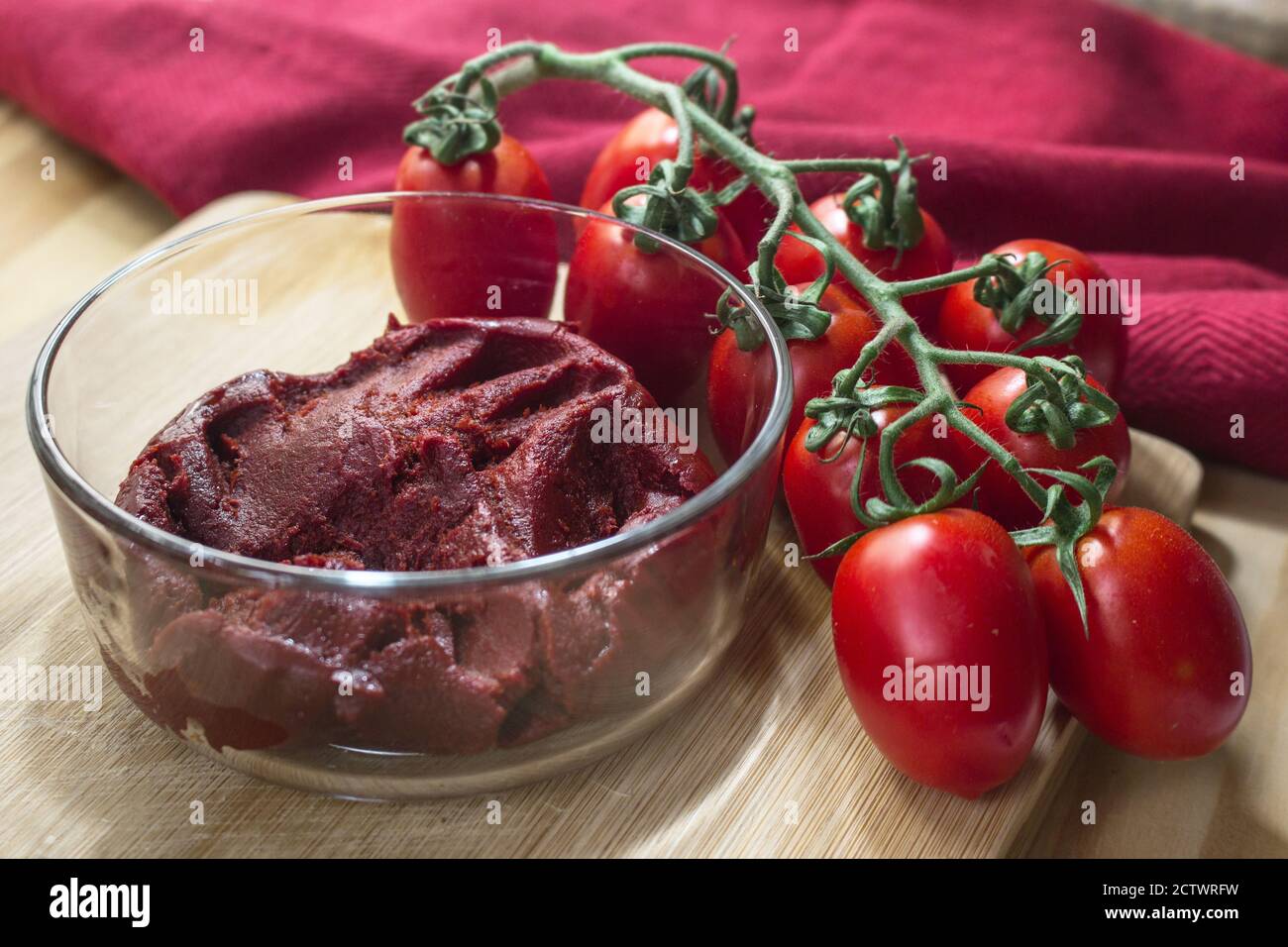 Sizilianische Produkte: Eine Schüssel mit konzentrierter Tomatensauce namens "Astratto", neben einem Bündel Piccadilly Tomaten. Stockfoto