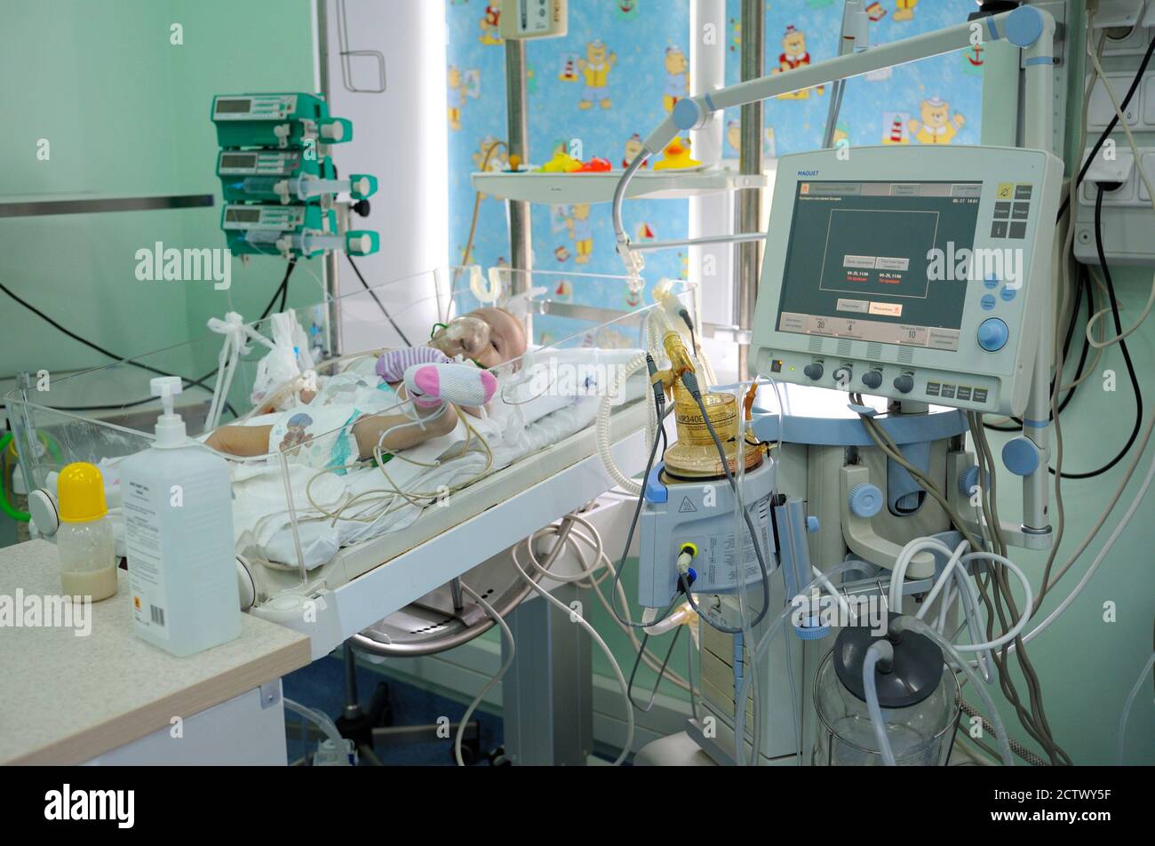 Auf der Intensivstation. Baby schläft auf einem Krankenhausbett, das an einen Wiederbelebungsapparat angeschlossen ist. Pressetour zum Ukrainischen Kinderkardialzentrum für Stockfoto