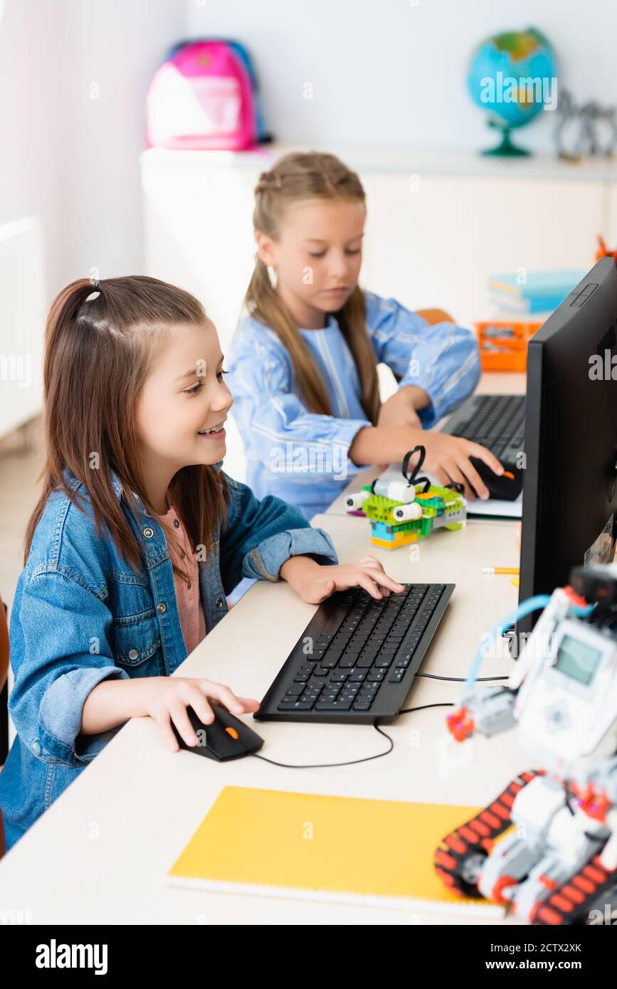 Selektiver Fokus von Schülerinnen, die Computer in der Nähe von Robotern im Stamm verwenden Schule Stockfoto