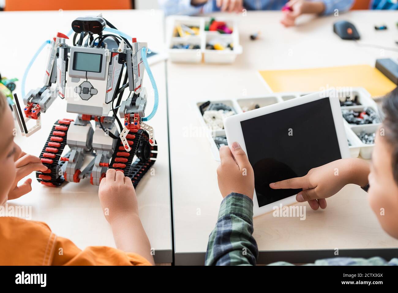 Selektive Fokus der asiatischen Schuljunge mit digitalen Tablet in der Nähe Freund Modellierroboter in der Schule Stockfoto