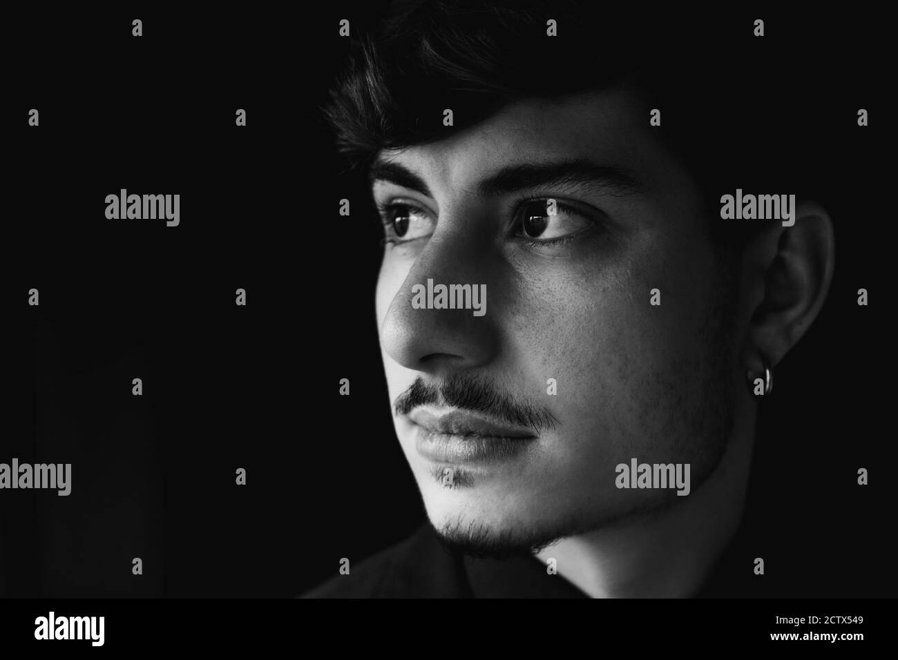 Graustufen Aufnahme eines coolen und schönen Kerl isoliert auf Ein dunkler Hintergrund Stockfoto