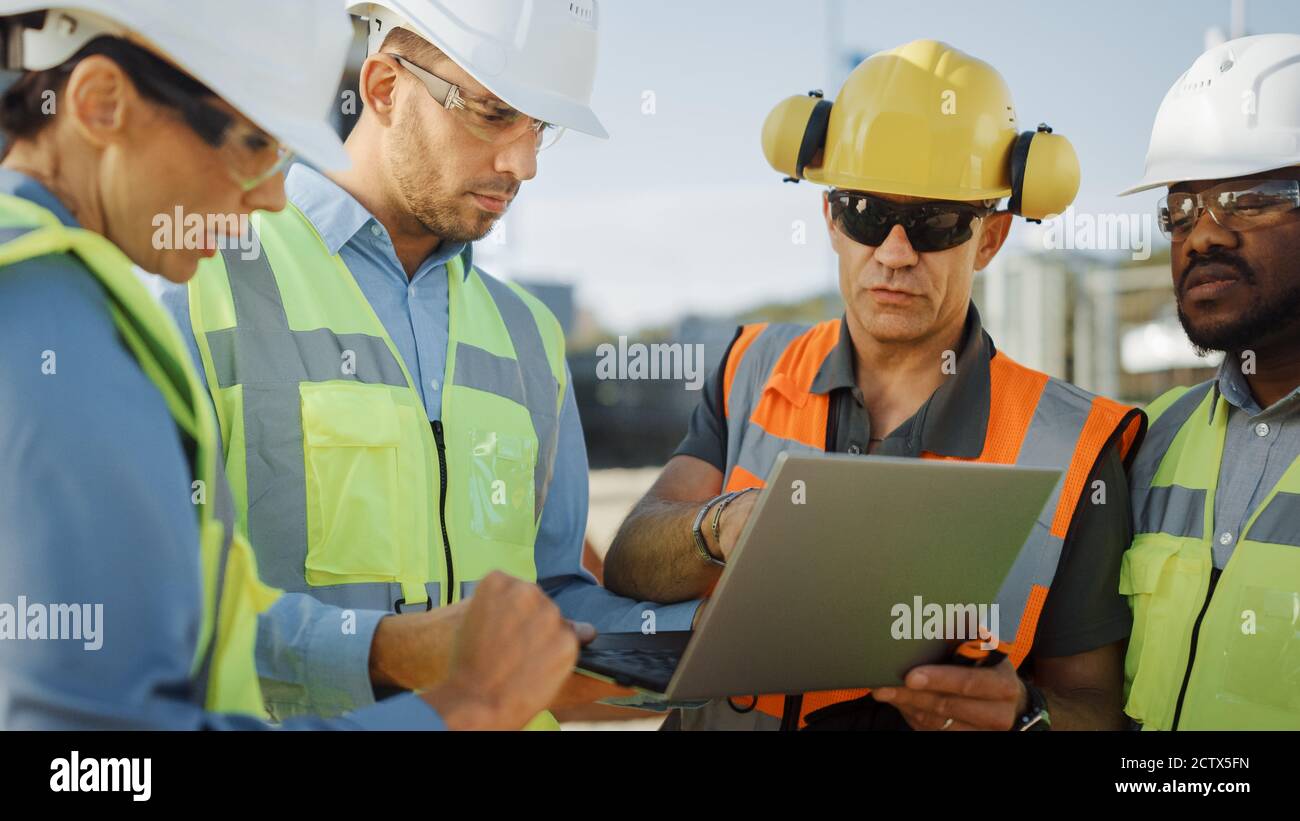 Diverse Team von Spezialisten verwenden Laptop-Computer auf der Baustelle. Immobilienbauprojekt mit Bauingenieur, Architekturinvestor Stockfoto