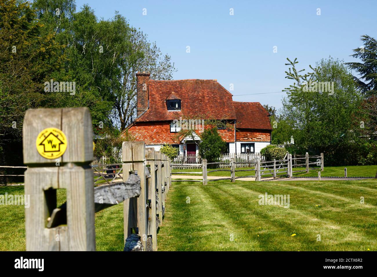 Manor Farm Cottage (ein kleines Bauernhaus aus dem 17. Jahrhundert) und Wealdway Fernwanderweg Zeichen auf fencepost, Lower Haysden, Kent, England Stockfoto