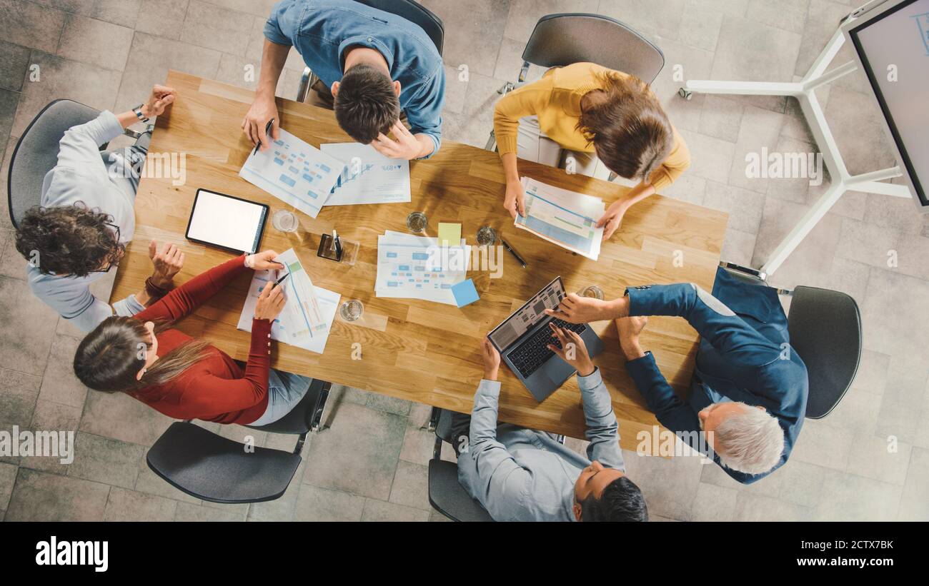 Startup Meeting Room: Team von Unternehmern sitzen am Konferenztisch haben Diskussionen, Probleme lösen, verwenden Sie Digital Tablet, Laptop, Dokumente teilen Stockfoto
