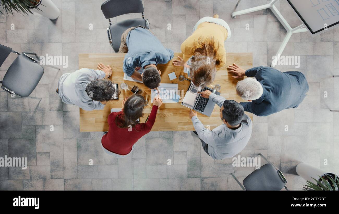 Startup Meeting Room: Team von Unternehmern stehen rund um Konferenztisch haben Diskussionen, Probleme zu lösen, verwenden Sie Digital Tablet, Laptop, Teilen Stockfoto