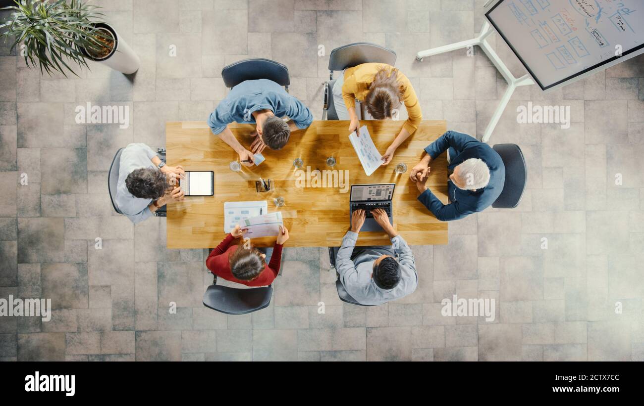 Startup Meeting Room: Team von Unternehmern sitzen am Konferenztisch haben Diskussionen, Probleme lösen, verwenden Sie Digital Tablet, Laptop, Teilen Stockfoto