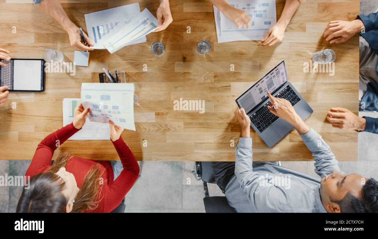Im Startup Meeting Room sitzen Unternehmer-Teams am Konferenztisch, diskutieren, lösen Probleme, nutzen Digital Tablet, Laptop Stockfoto