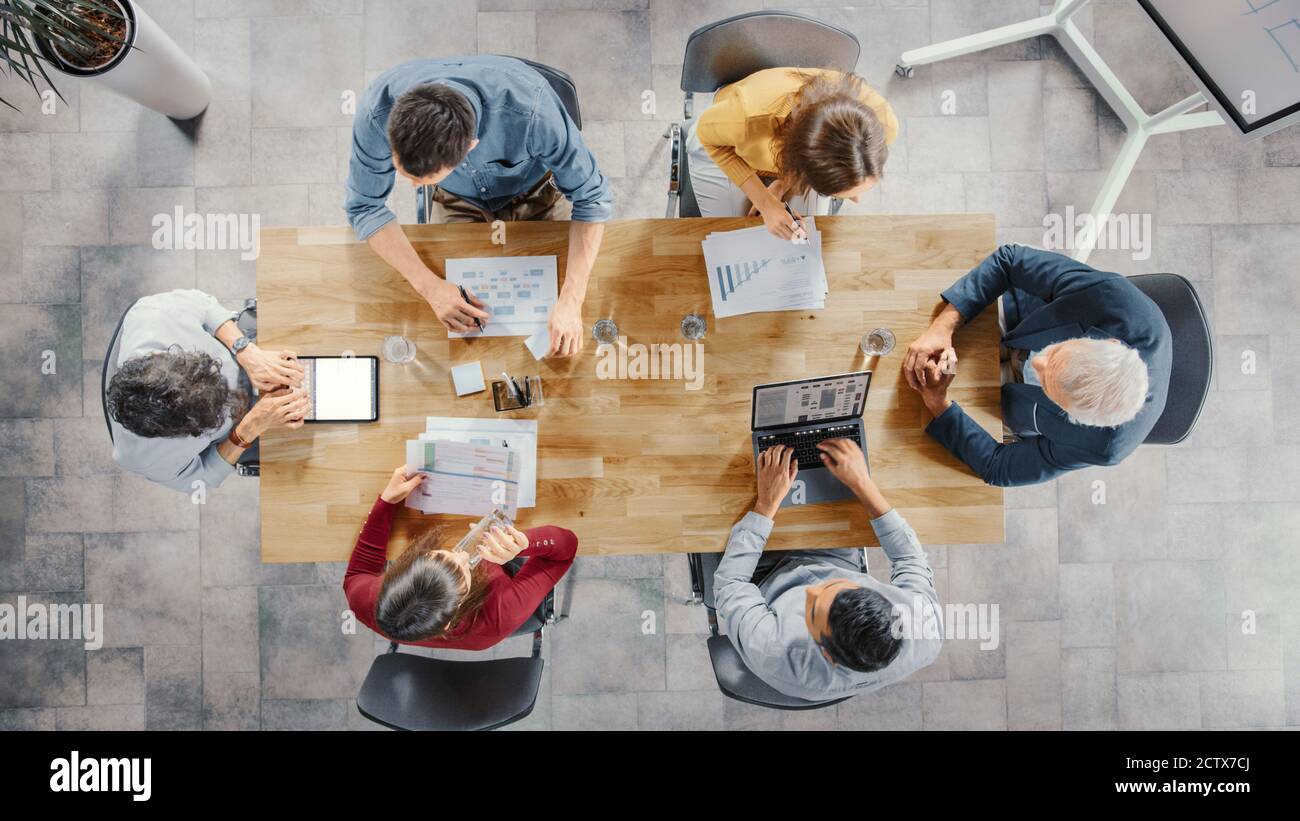 Startup Meeting Room: Team von Unternehmern sitzen am Konferenztisch haben Diskussionen, Probleme lösen, verwenden Sie Digital Tablet, Laptop, Teilen Stockfoto