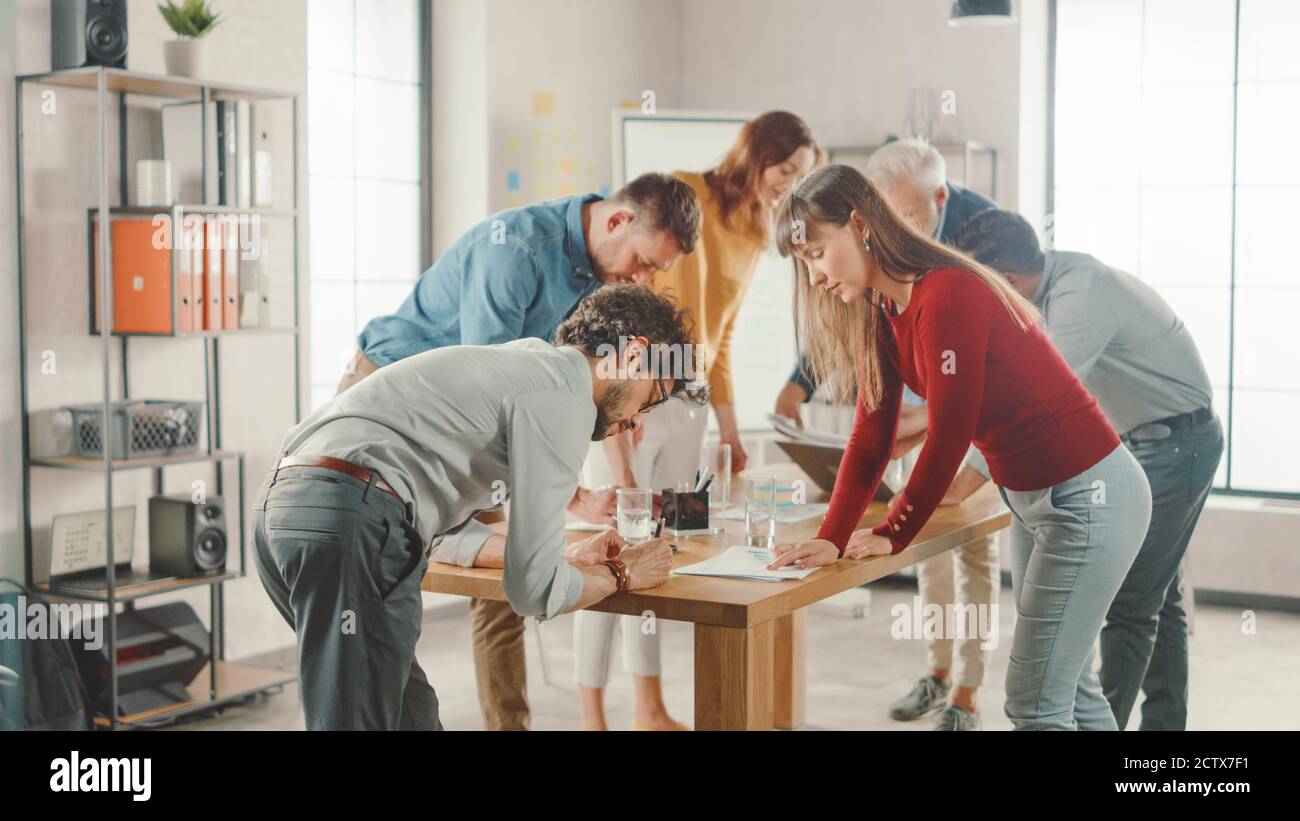 Startup Meeting Room: Team von Unternehmern versammeln sich um Konferenztisch Haben Diskussionen, Probleme lösen, verwenden Sie Digital Tablet Laptop, Teilen Stockfoto