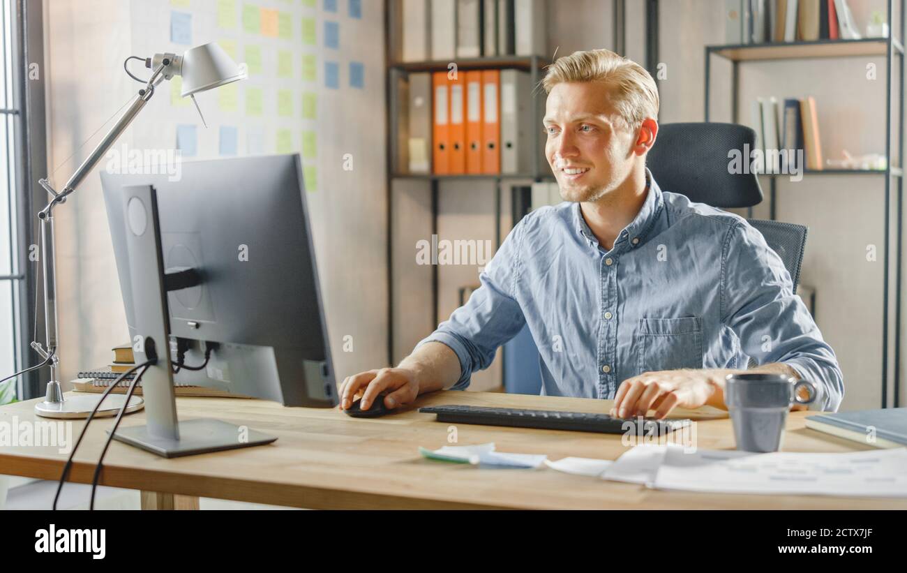 Creative Entrepreneur sitzt an seinem Schreibtisch arbeitet auf Desktop-Computer im stilvollen Büro. Handsome Kaukasischen Mann Verwendet Computer. Im Hintergrund Stockfoto