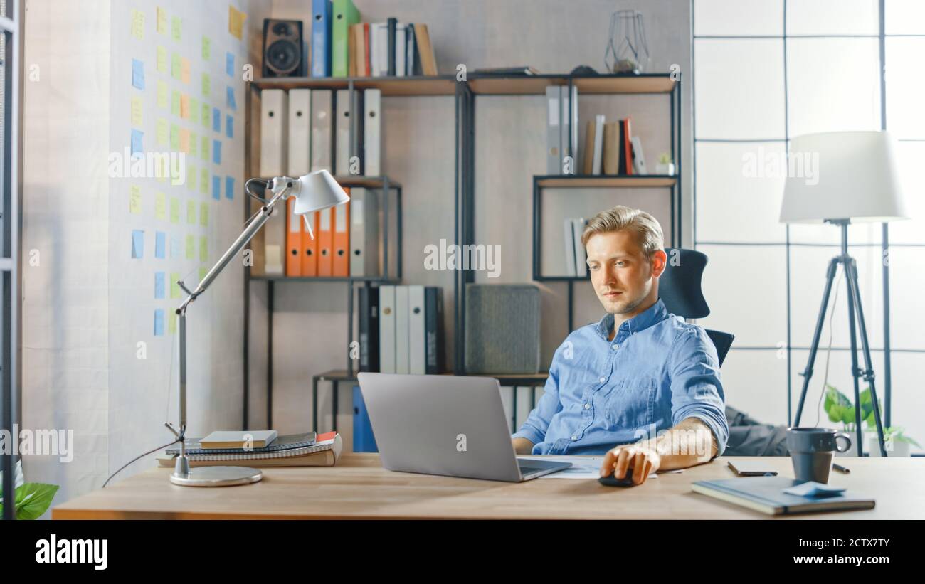 Creative Entrepreneur sitzt an seinem Schreibtisch arbeitet auf einem Laptop im stilvollen Büro, nutzt Notebook für Social Media Apps, E-Mail-Business Associates Stockfoto