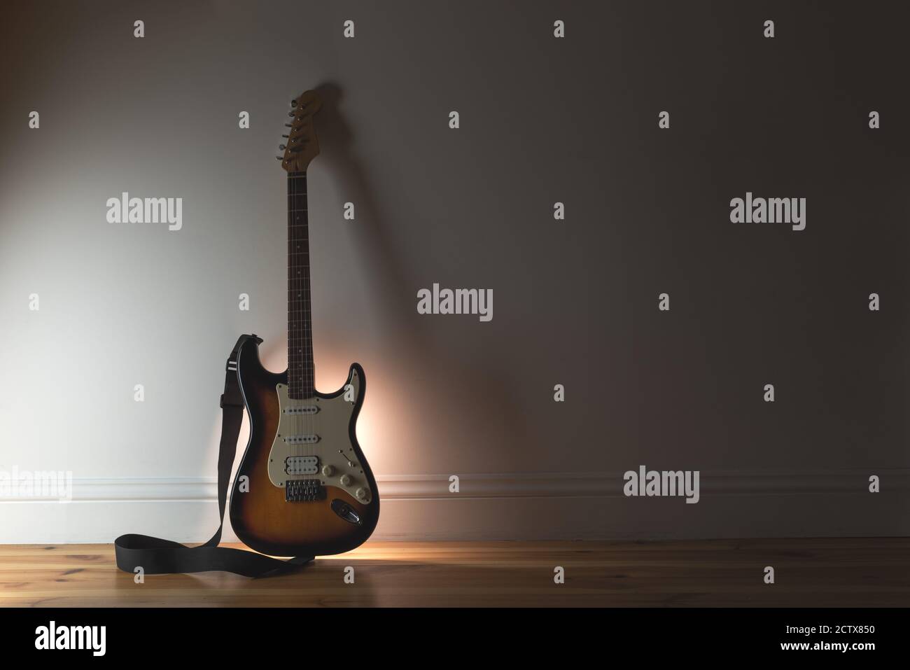 Musik Sound Hintergrund mit klassischer Elektro-Gitarre und schwarzem Kabel Auf Wandhintergrund Stockfoto