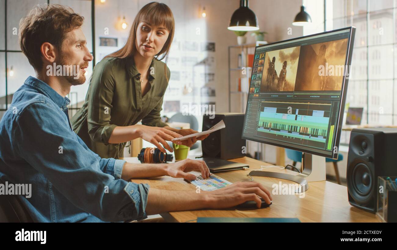 Beautiful Female Art Director konsultiert Handsome Video Editor Kollegin, sie arbeiten an einem Video-Projekt über Astronauten. Sie arbeiten in einem Cool Office Loft Stockfoto