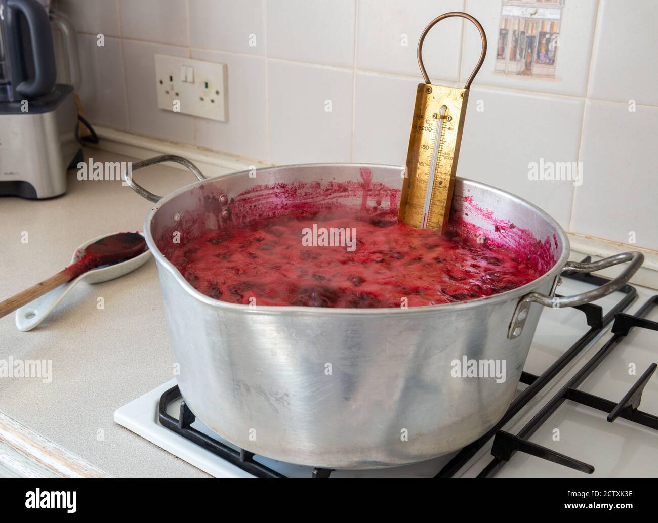 Marmelade machen - ein traditionelles Messingthermometer in einer Konservierung Pfanne mit kochender Brombeere und Apfelmarmelade Stockfoto