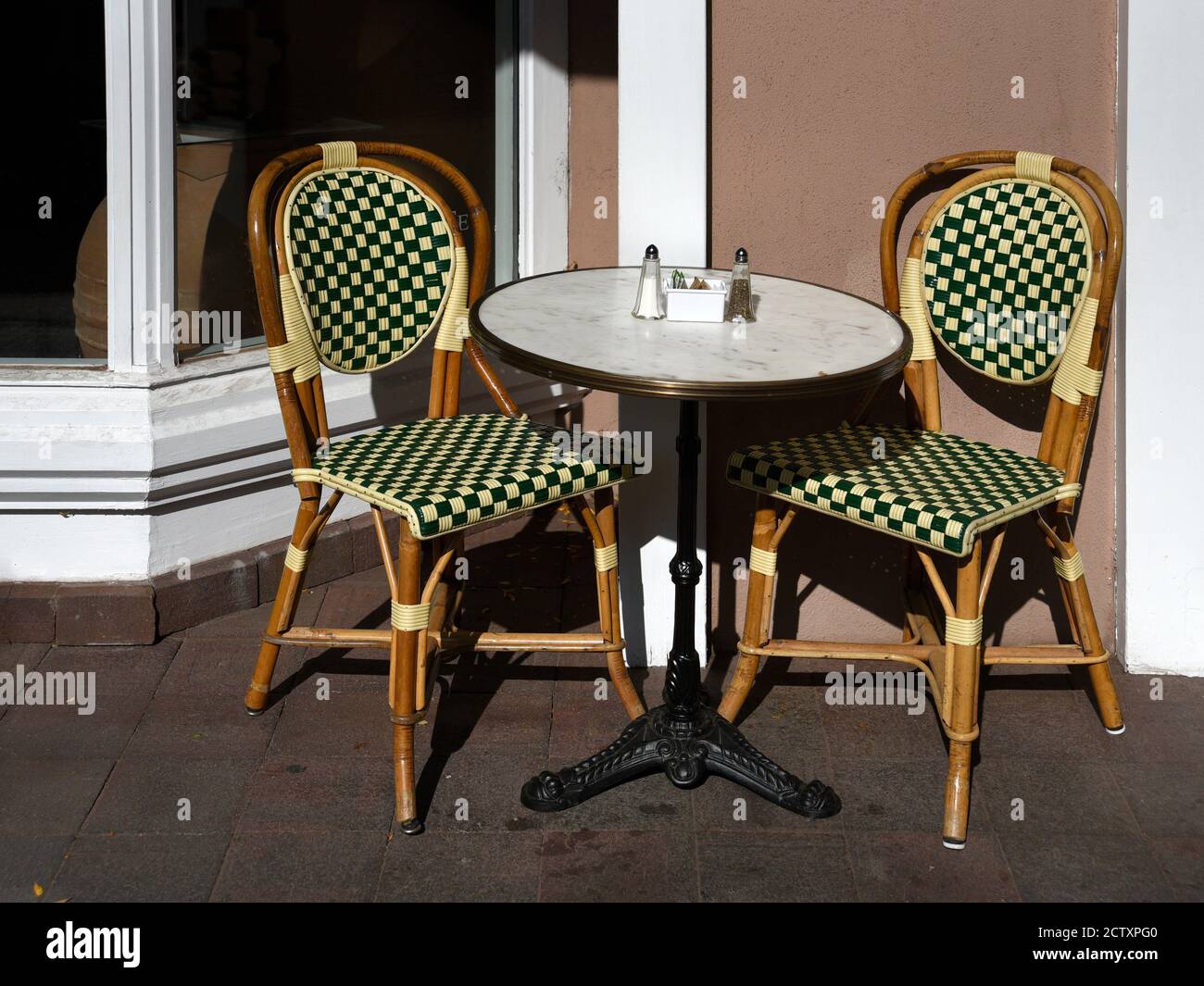 Ein Tisch und Stühle auf dem Bürgersteig vor einem kleinen Restaurant und einer Bäckerei in Santa Fe, New Mexico. Stockfoto