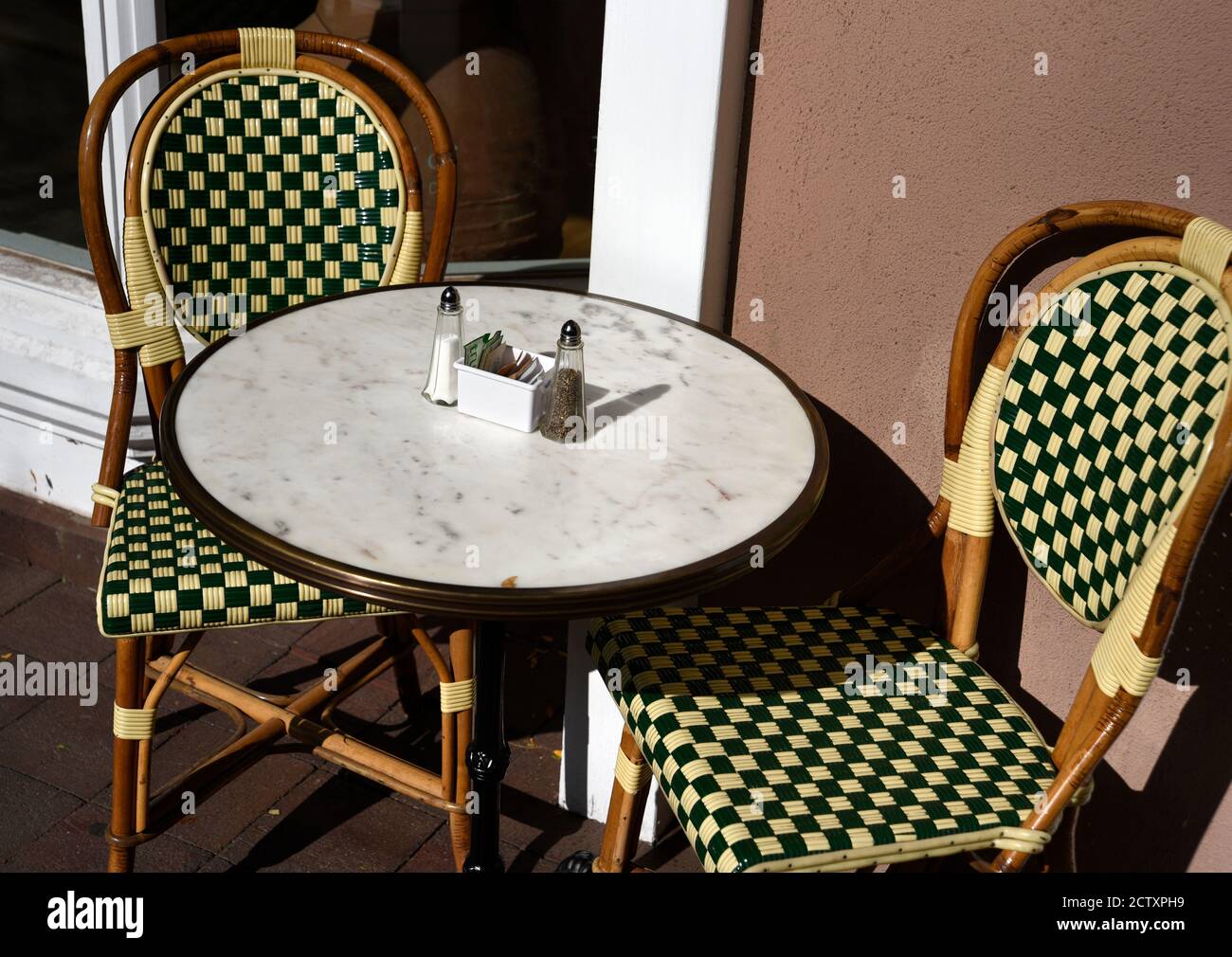 Ein Tisch und Stühle auf dem Bürgersteig vor einem kleinen Restaurant und einer Bäckerei in Santa Fe, New Mexico. Stockfoto