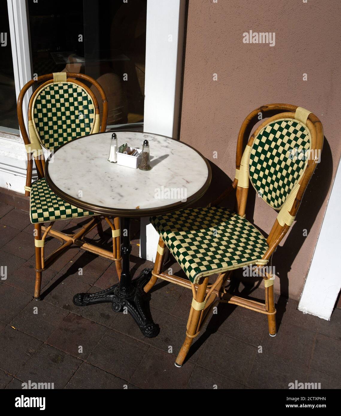 Ein Tisch und Stühle auf dem Bürgersteig vor einem kleinen Restaurant und einer Bäckerei in Santa Fe, New Mexico. Stockfoto