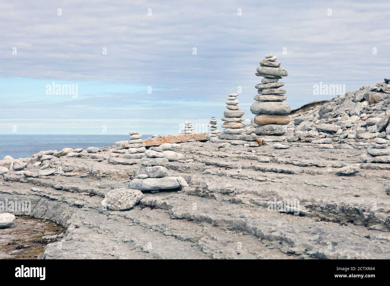 Steine balancieren, Kieselsteine stapeln sich über blauem Meer in Estland in Osmussaar island. Blauer Himmel an der ostseeküste im Sommer. Stockfoto