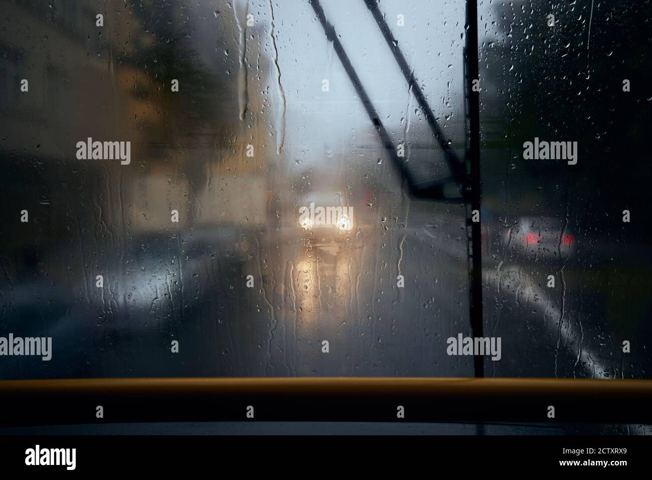 Verkehr auf der Stadtstraße bei starkem Regen. Blick vom Straßenbahnfenster. Düsterer Tag in Prag, Tschechische Republik. Stockfoto