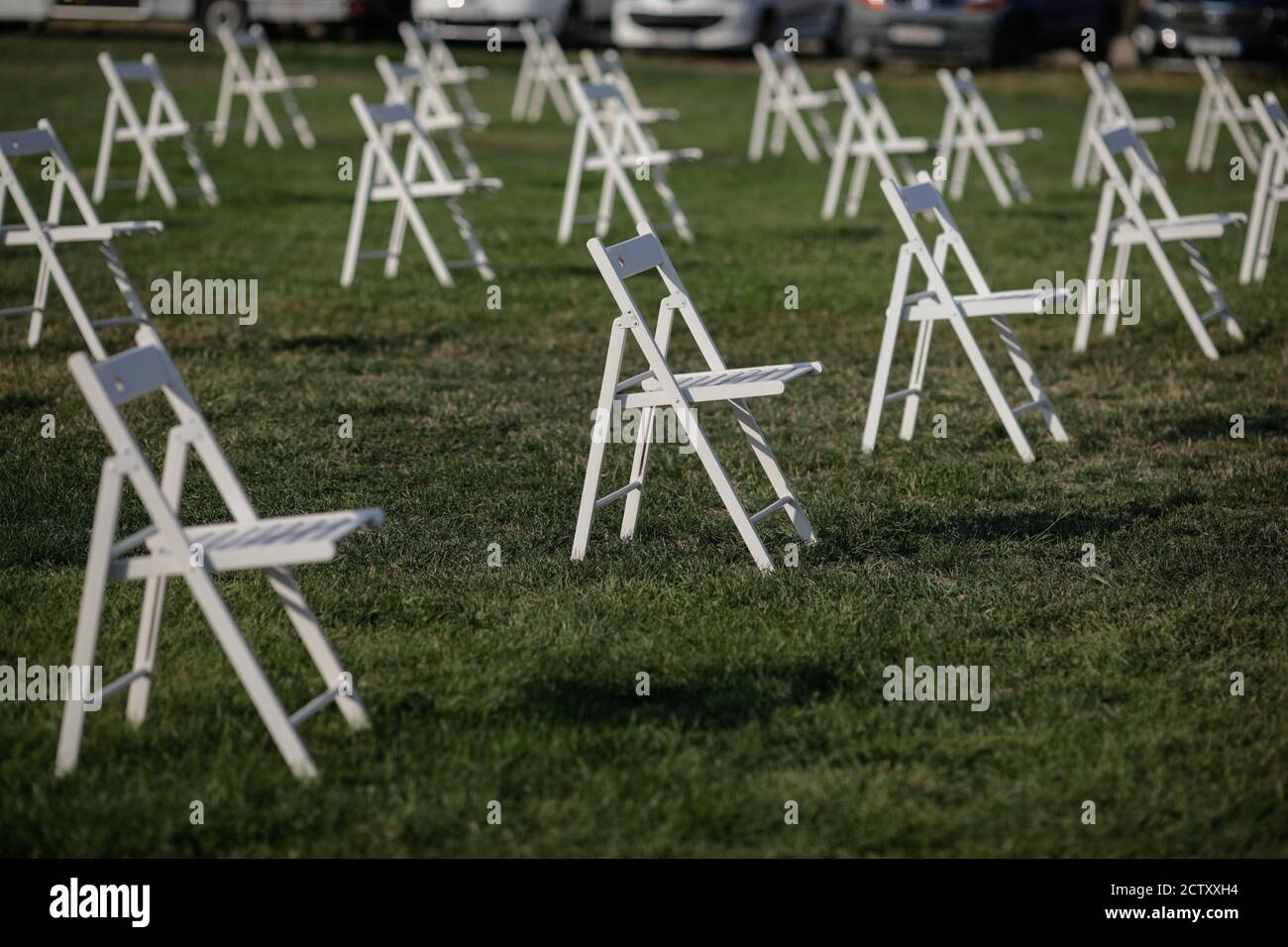 Stühle auseinander, um die soziale Distanz zu halten Während des Covid-19 Ausbruchs bei einem Outdoor-Event auf dem Gras Stockfoto