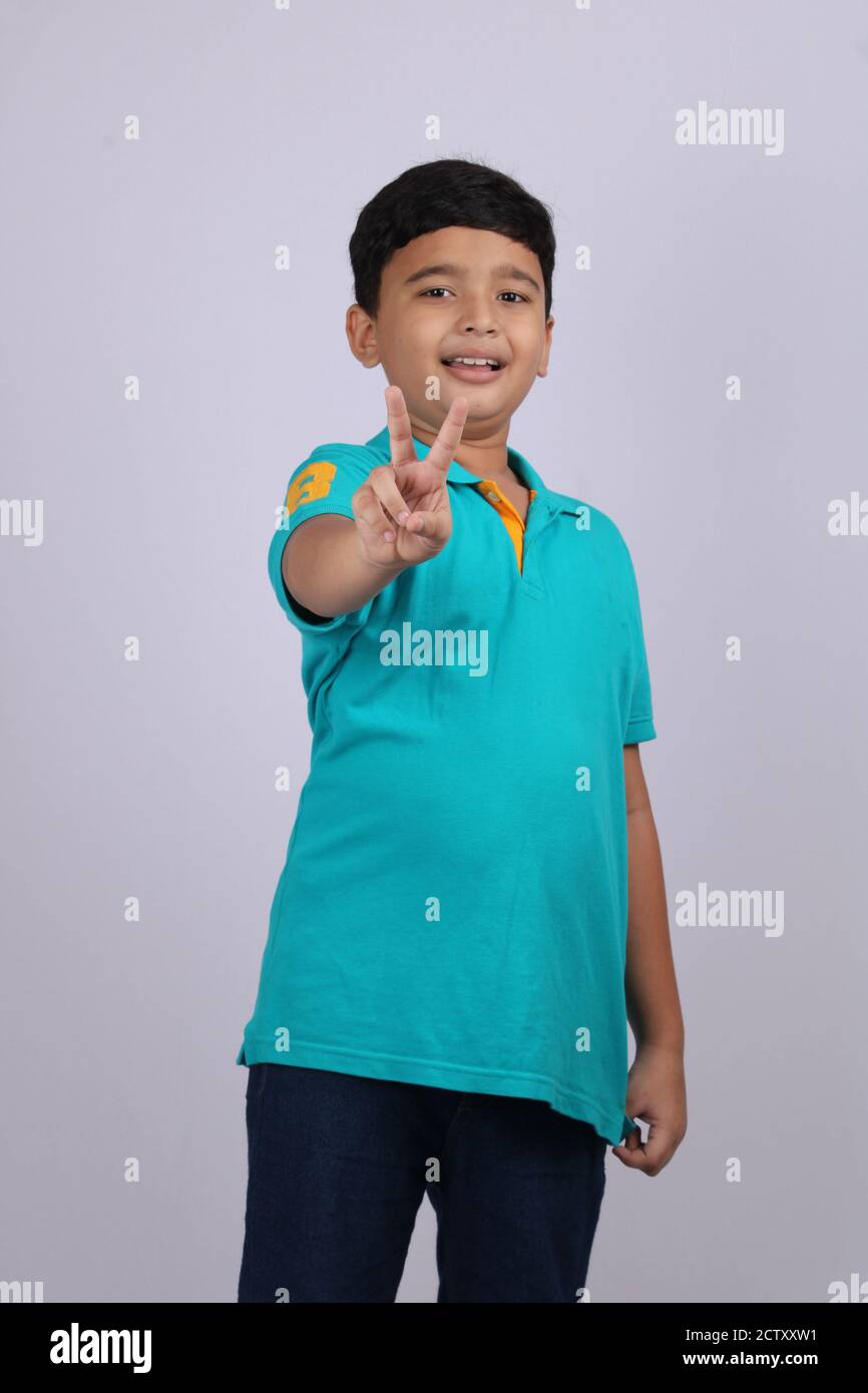 Niedlich und smart indischen Jungen Anzeige Pose. Es ist ein nach vorne gerichtete Foto, wo Junge sieht zuversichtlich und drückt sich mit der Hand Geste. Stockfoto
